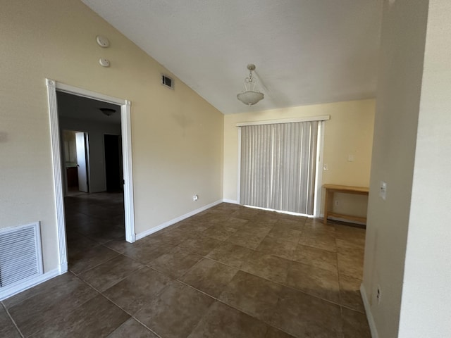 1433 SW San Esteban Ave, Port Saint Lucie, FL 34953 - spare room featuring lofted ceiling, dark tile patterned flooring, baseboards, and a smoke detector