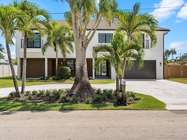 8 Leeward Cir, Tequesta, FL 33469 - view of front of property featuring curved driveway, a garage, fence, and stucco siding