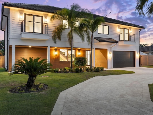8 Leeward Cir, Tequesta, FL 33469 - view of front of house featuring a balcony, a garage, a yard, driveway, and stucco siding