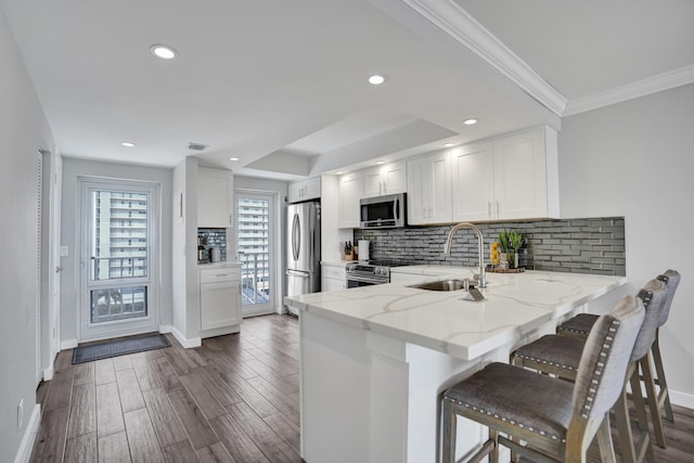 3100 S Ocean Blvd Unit 620, Highland Beach, FL 33487 - kitchen with a sink, stainless steel appliances, light stone counters, baseboards, and a peninsula