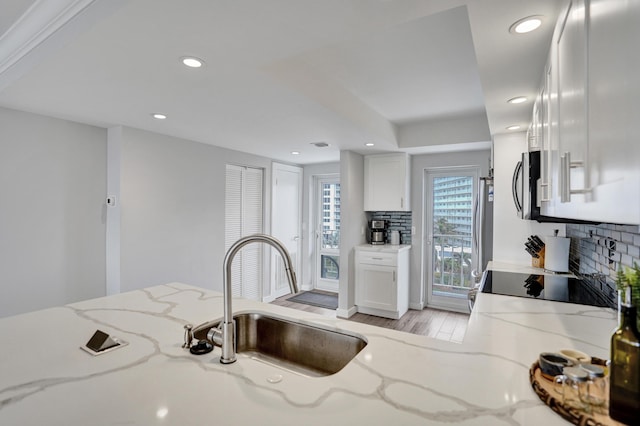 3100 S Ocean Blvd Unit 620, Highland Beach, FL 33487 - kitchen featuring tasteful backsplash, stainless steel microwave, a sink, recessed lighting, and light wood-type flooring