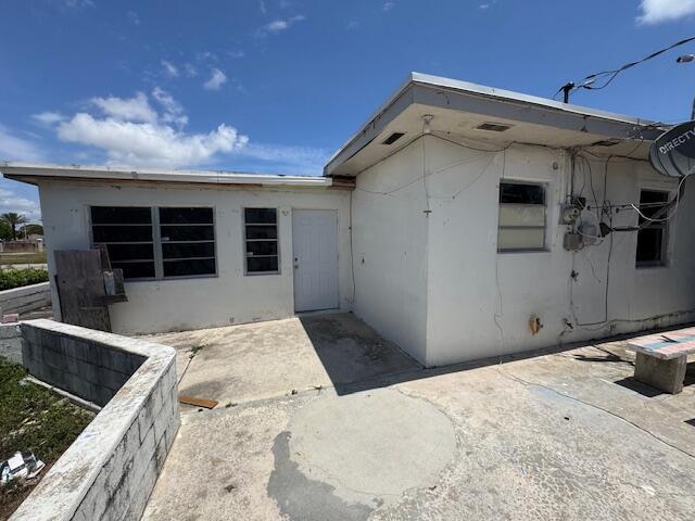 rear view of property featuring a patio and stucco siding