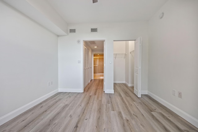 350 N Federal Hwy SE Unit 506, Boynton Beach, FL 33435 - unfurnished bedroom featuring light wood-style flooring, baseboards, a closet, and a walk in closet
