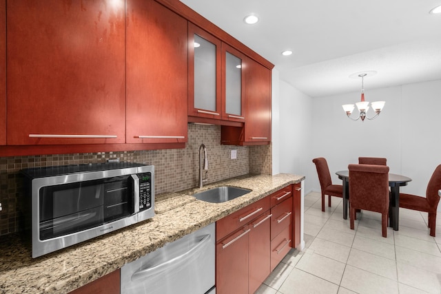 250 NE 20th St Unit 1220, Boca Raton, FL 33431 - kitchen with stainless steel appliances, a sink, backsplash, a chandelier, and light tile patterned floors