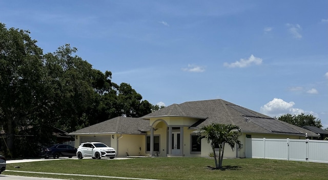 1601 SW California Blvd, Port Saint Lucie, FL 34953 - view of front of property with an attached garage, a gate, stucco siding, roof with shingles, and solar panels