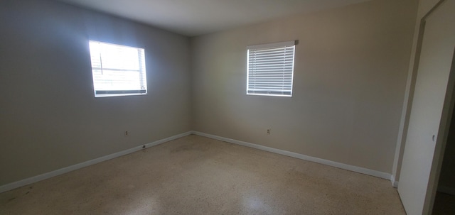717 Hollywood Pl, West Palm Beach, FL 33405 - empty room with dark aggregate flooring and baseboards