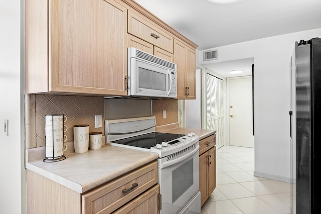 1180 S Ocean Blvd Unit 7B, Boca Raton, FL 33432 - kitchen with white appliances, light brown cabinets, light countertops, decorative backsplash, and light tile patterned floors