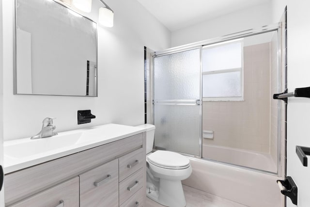 full bath with vanity, toilet, and combined bath / shower with glass door
