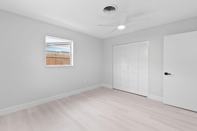 unfurnished bedroom featuring light wood-type flooring, a closet, baseboards, and a ceiling fan