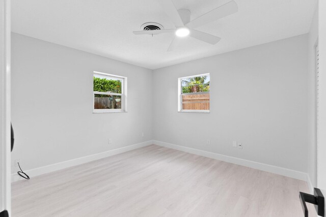 unfurnished room with light wood finished floors, baseboards, and a ceiling fan
