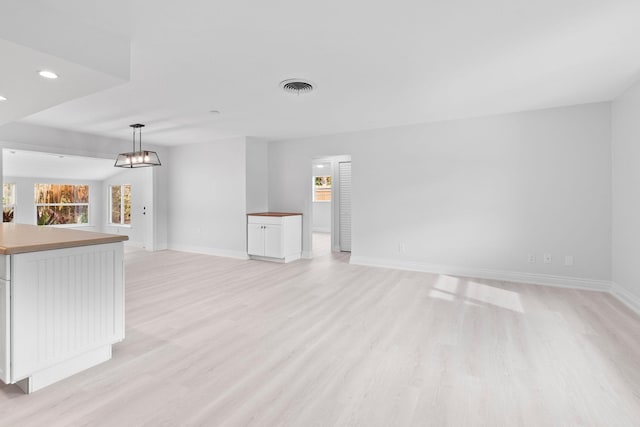 unfurnished living room featuring light wood-type flooring, baseboards, and recessed lighting