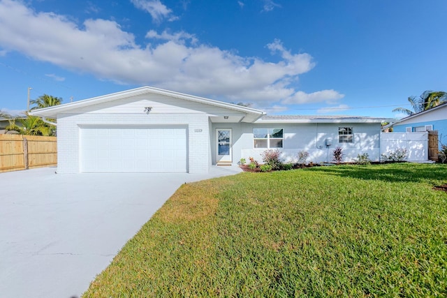 single story home with concrete driveway, an attached garage, and brick siding