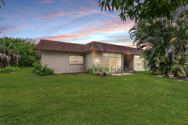 1920 Palmland Dr Unit C, Boynton Beach, FL 33436 - rear view of house with mansard roof, a lawn, and stucco siding