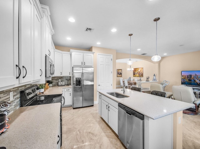 11416 SW Lake Park Dr, Port Saint Lucie, FL 34987 - kitchen with stainless steel appliances, a sink, tasteful backsplash, open floor plan, and white cabinetry