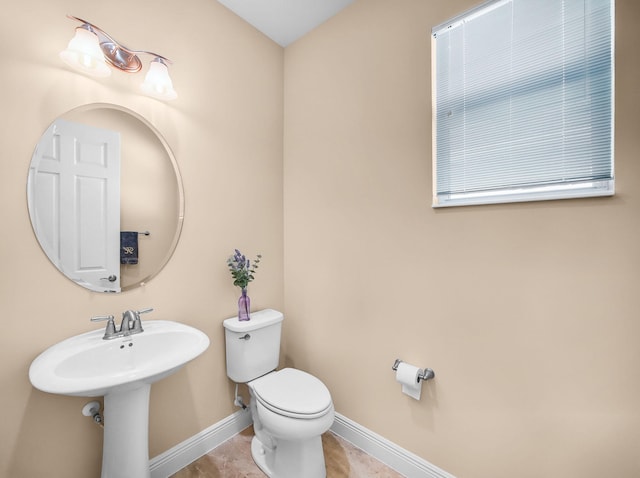 11416 SW Lake Park Dr, Port Saint Lucie, FL 34987 - half bathroom with baseboards, toilet, tile patterned flooring, and a sink