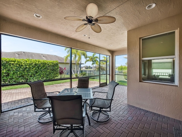 11416 SW Lake Park Dr, Port Saint Lucie, FL 34987 - sunroom with a textured wall, a ceiling fan, a textured ceiling, brick floors, and outdoor dining space