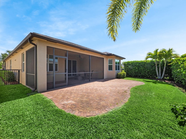 11416 SW Lake Park Dr, Port Saint Lucie, FL 34987 - back of house featuring a patio, a sunroom, stucco siding, and a yard