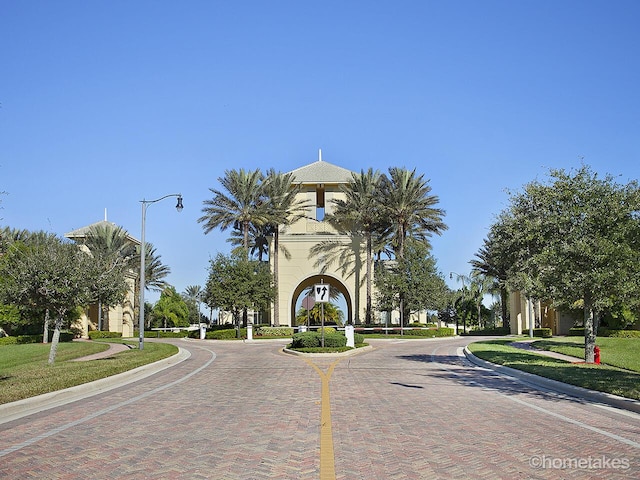 11416 SW Lake Park Dr, Port Saint Lucie, FL 34987 - view of decorative road with curbs, street lights, and sidewalks