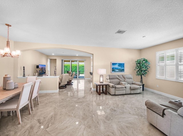 11416 SW Lake Park Dr, Port Saint Lucie, FL 34987 - living room featuring a chandelier, light marble finish flooring, arched walkways, baseboards, and a textured ceiling