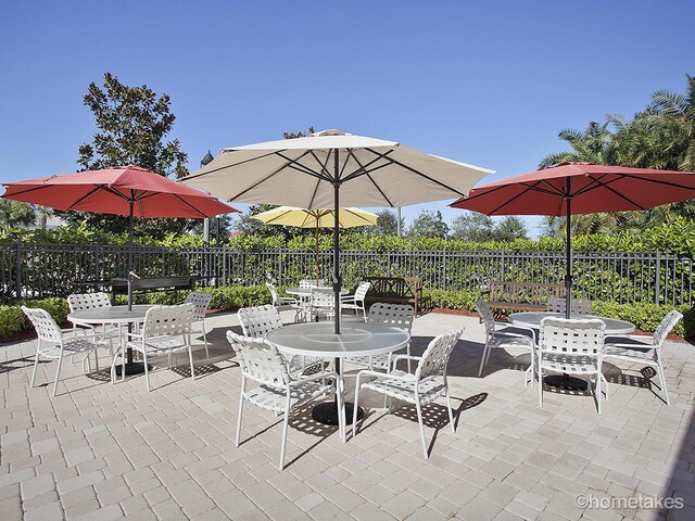 11416 SW Lake Park Dr, Port Saint Lucie, FL 34987 - view of patio / terrace featuring outdoor dining area and fence