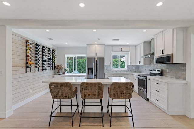 5830 SW 51st Ter, Miami, FL 33155 - kitchen featuring stainless steel appliances, a breakfast bar, light countertops, white cabinets, and decorative backsplash