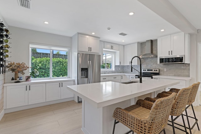 5830 SW 51st Ter, Miami, FL 33155 - kitchen with appliances with stainless steel finishes, wall chimney exhaust hood, a sink, a kitchen bar, and light countertops
