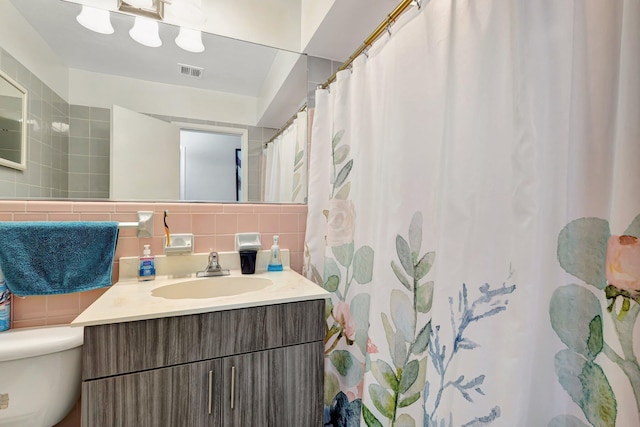 2425 S Florida Mango Rd, West Palm Beach, FL 33406 - bathroom with tasteful backsplash, vanity, tile walls, and toilet