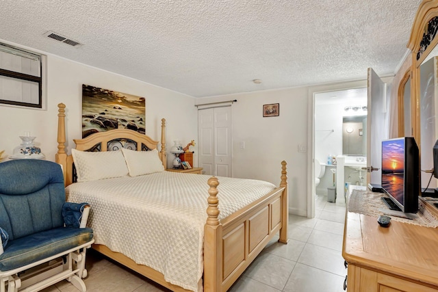 2425 S Florida Mango Rd, West Palm Beach, FL 33406 - bedroom featuring light tile patterned floors, connected bathroom, and a closet