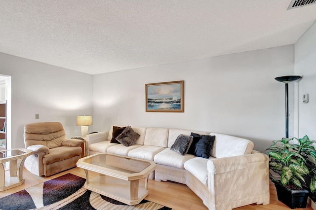 living area with light wood-style floors and a textured ceiling