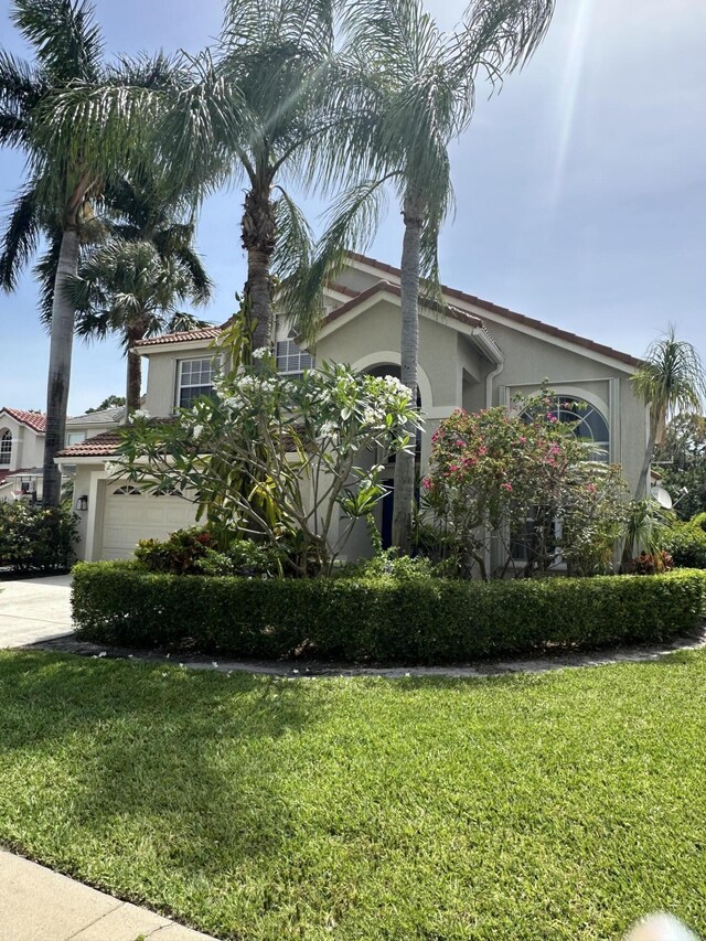 207 Pennock Trace Dr, Jupiter, FL 33458 - view of side of home with stucco siding, a lawn, and concrete driveway