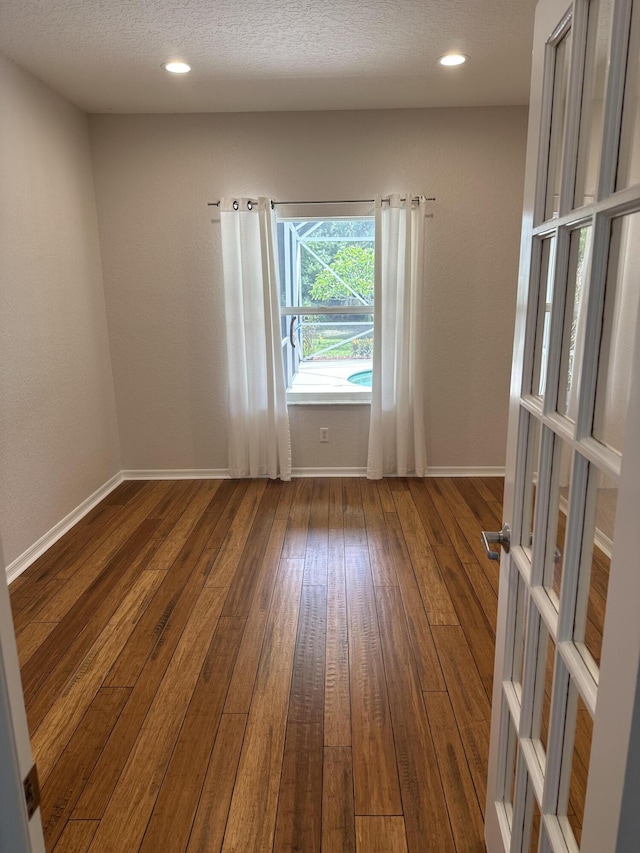 207 Pennock Trace Dr, Jupiter, FL 33458 - unfurnished room with wood-type flooring, baseboards, and a textured ceiling