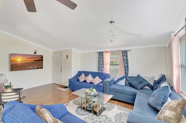 living room featuring vaulted ceiling, wood finished floors, a ceiling fan, crown molding, and a chandelier