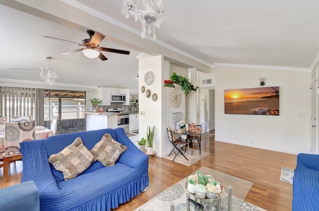 living room featuring lofted ceiling, a chandelier, a ceiling fan, light wood-style floors, and ornamental molding