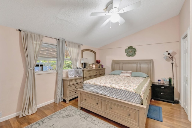 bedroom with light wood-style floors, vaulted ceiling, a ceiling fan, and baseboards
