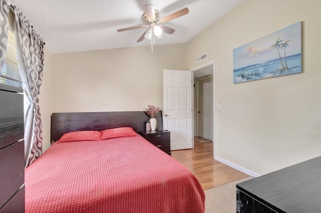 bedroom with ceiling fan, baseboards, and light wood-type flooring
