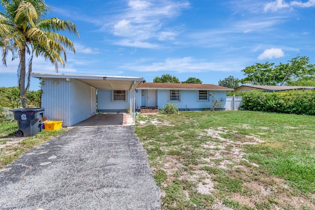 ranch-style house featuring asphalt driveway and an attached carport
