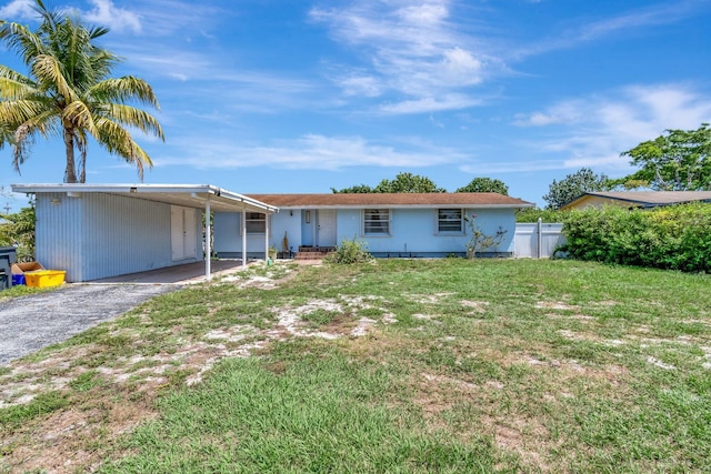 single story home featuring a carport and asphalt driveway