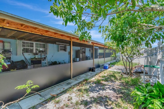 view of yard featuring fence and a sunroom
