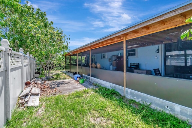 view of yard with fence and a sunroom