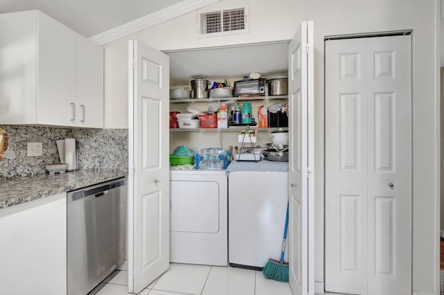 laundry room featuring washer and clothes dryer, light tile patterned floors, and ornamental molding
