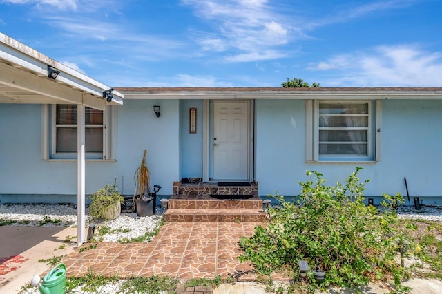 view of exterior entry featuring stucco siding