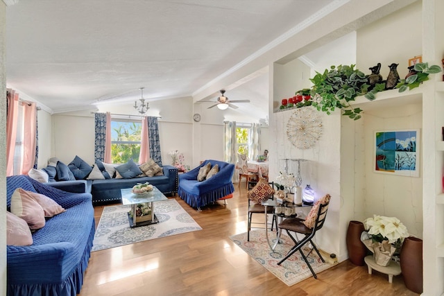 living area with vaulted ceiling, wood finished floors, a chandelier, and a ceiling fan