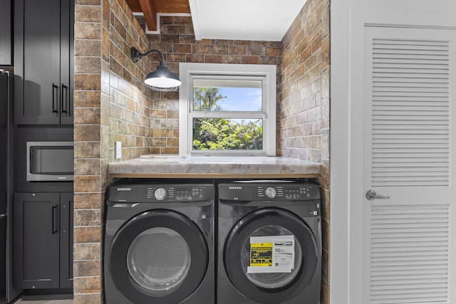 laundry area featuring separate washer and dryer and cabinet space