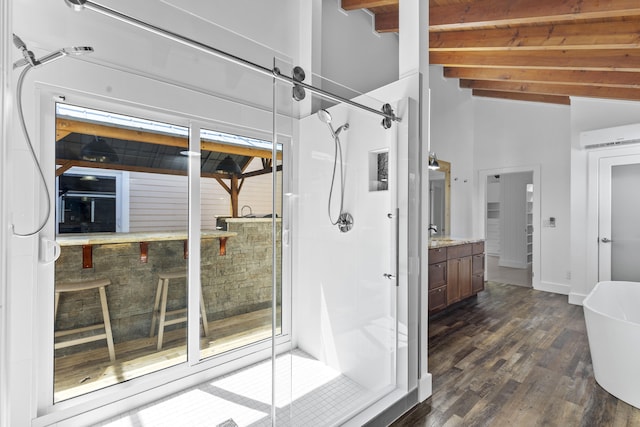 bathroom with a shower stall, beamed ceiling, wood finished floors, vanity, and baseboards