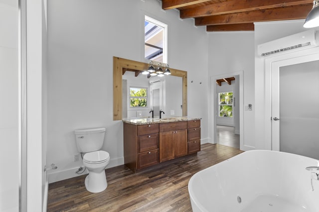 bathroom featuring an AC wall unit, a freestanding tub, plenty of natural light, wood finished floors, and beam ceiling