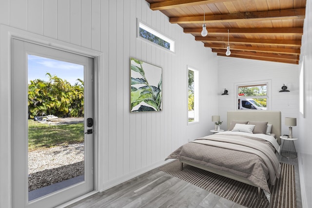 bedroom with wood finished floors, wood ceiling, wooden walls, and access to outside