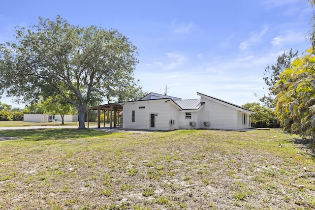 view of side of property with a yard, a patio, metal roof, and a standing seam roof