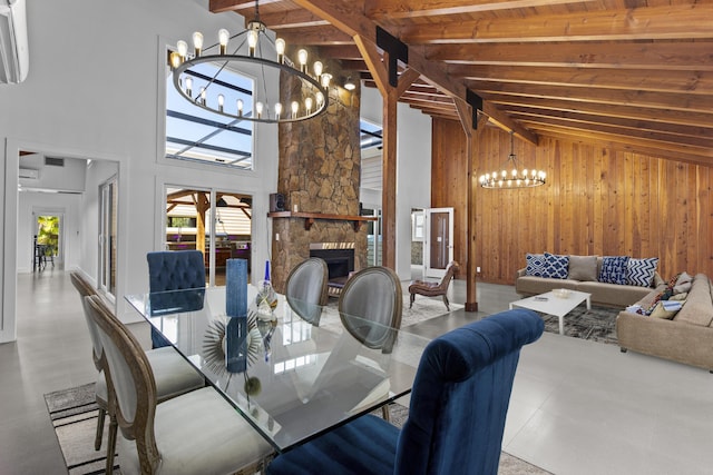dining room featuring a chandelier, beamed ceiling, wooden walls, a fireplace, and high vaulted ceiling