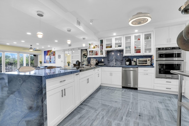 1537 E Hillsboro Blvd Unit 341, Deerfield Beach, FL 33441 - kitchen with appliances with stainless steel finishes, dark countertops, a sink, a peninsula, and backsplash