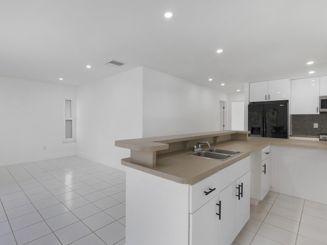 1138 SW Gardena Ave, Port Saint Lucie, FL 34953 - kitchen featuring a sink, black fridge, recessed lighting, light tile patterned floors, and tasteful backsplash